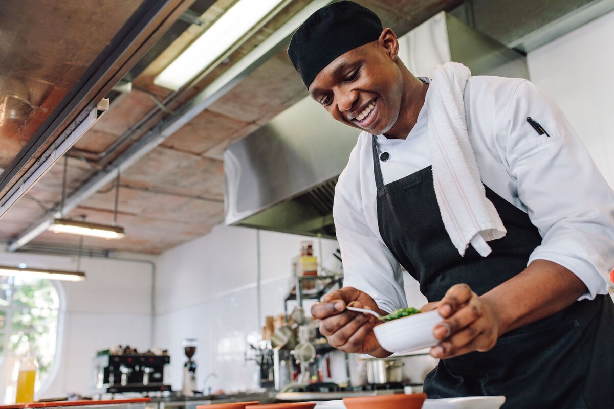 A chef plating fresh food in a community kitchen