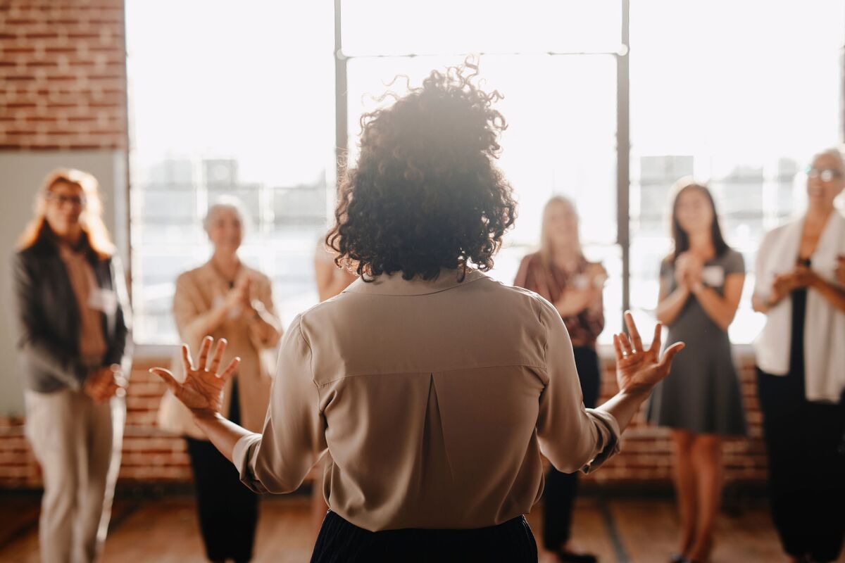 A woman addressing a standing audience at a foundation gathering